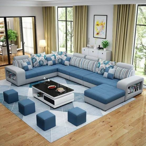 A blue-grey U-shaped sectional sofa with ottomans in a styled living room